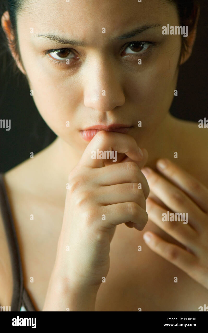 Woman with hand under chin looking intently at camera Stock Photo