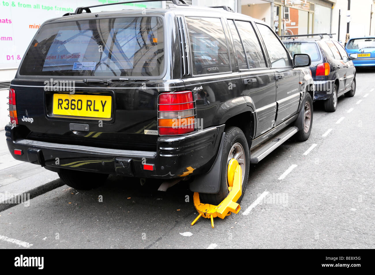 Police wheel clamp on a car parked in a no parking zone, London