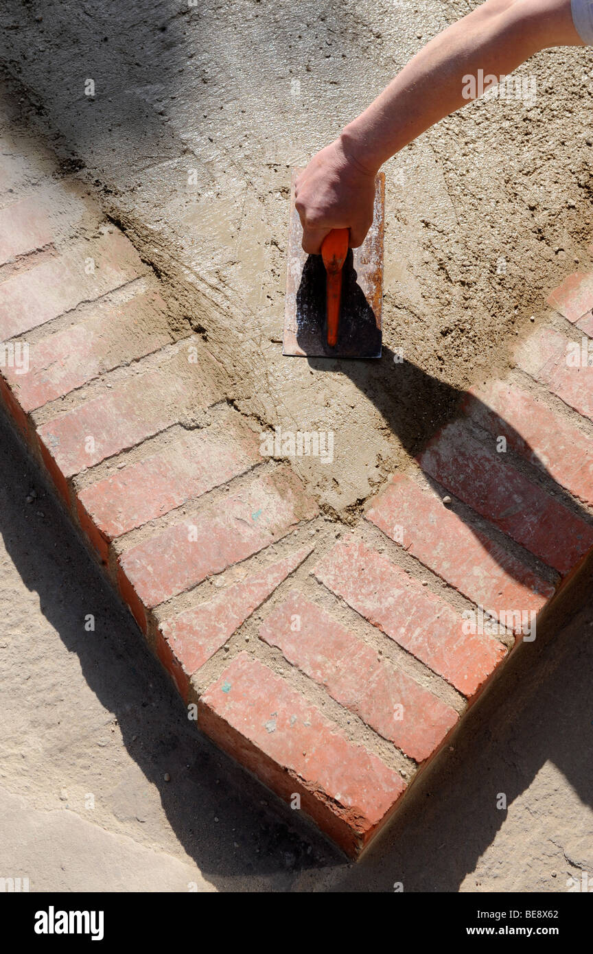 DETAIL OF SMOOTHING CONCRETE WITH A BUILDERS FLOAT IN CONSTRUCTION OF A HARD STANDING PARKING AREA UK Stock Photo