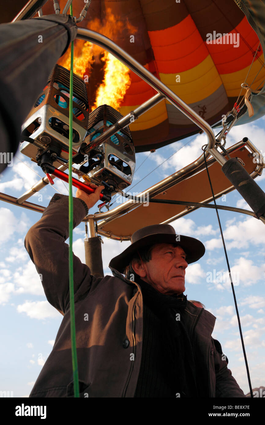 Hot Air Balloon pilot controls the altitude by firing the burners (Namibia) Stock Photo