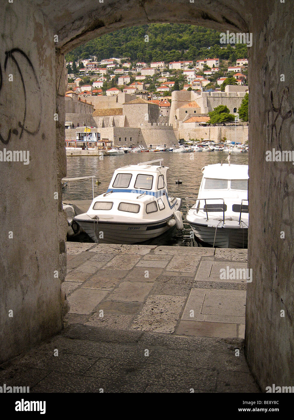 Croatia Hrvartska Kroatien Dubrovnik Fishboat small tourist boat harbor harbour old City arch door way wall Stock Photo
