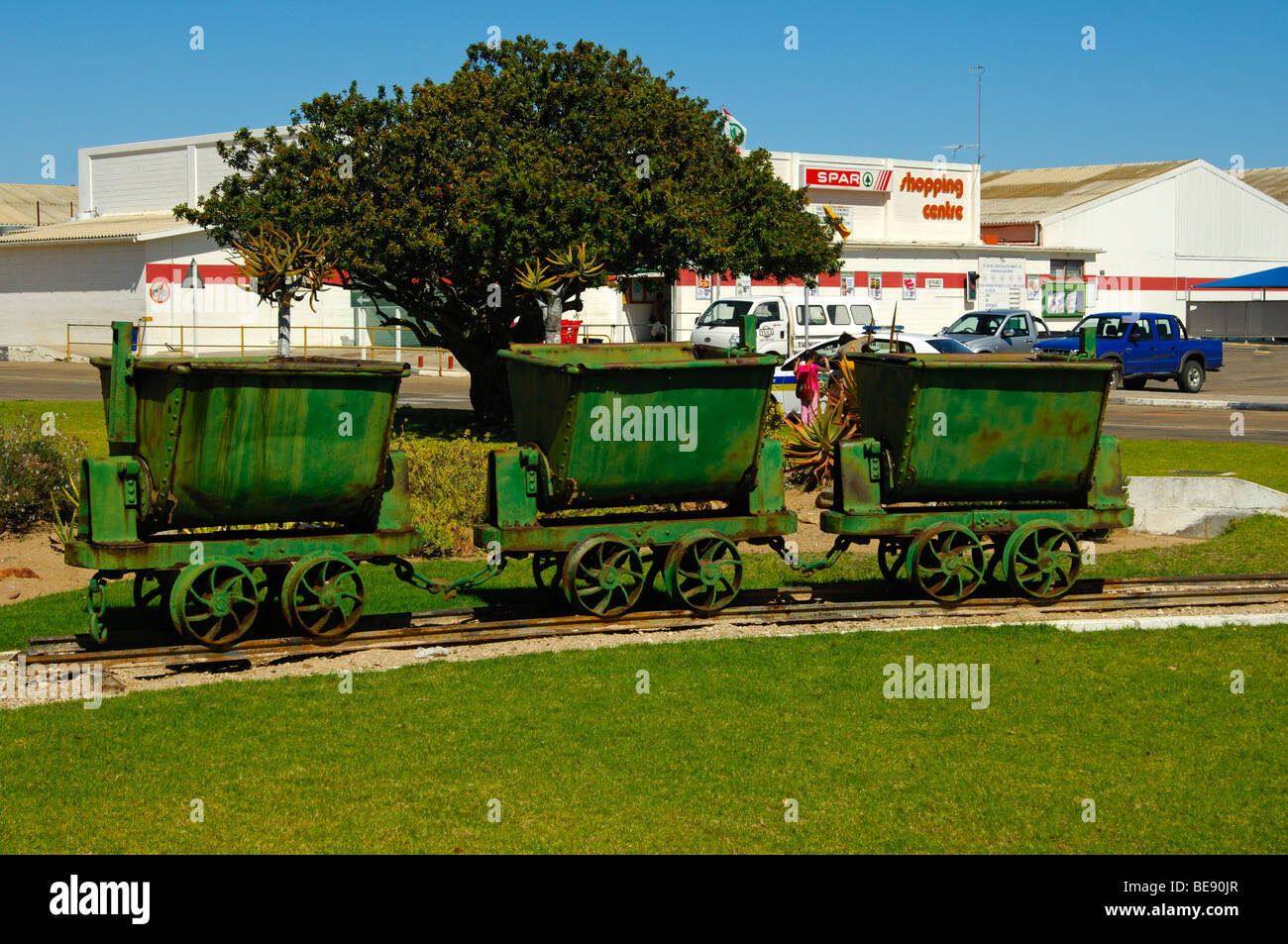 Old mine carts in front of the Spar Supermarket in the access-restricted De Beers diamond town Kleinzee, Northern Cape, South A Stock Photo