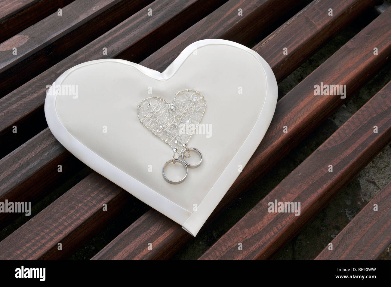 Heart-shaped ring pillow with wedding rings Stock Photo