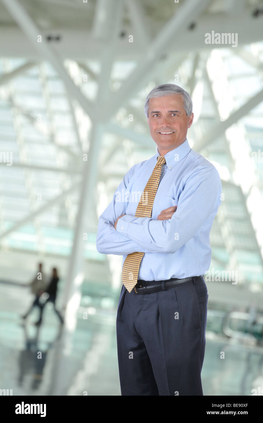 Man In Building Standing Businessman with arms crossed in Building Lobby with Blurred ...
