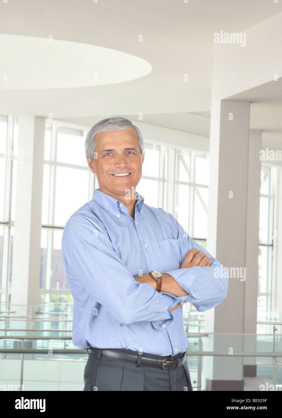 Smiling Businessman Standing In Office Setting With His Arms Crossed ...