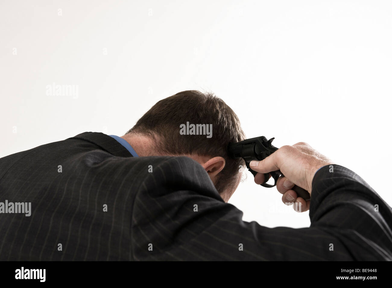 Man wearing a suit, holding gun to his head Stock Photo