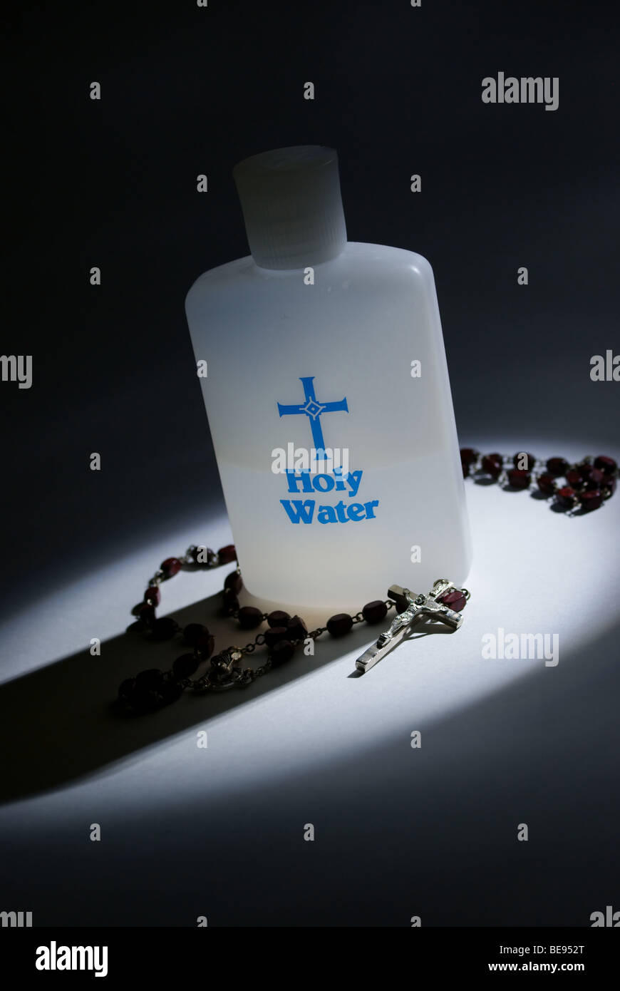 Holy water and rosary in a spot light Stock Photo Alamy