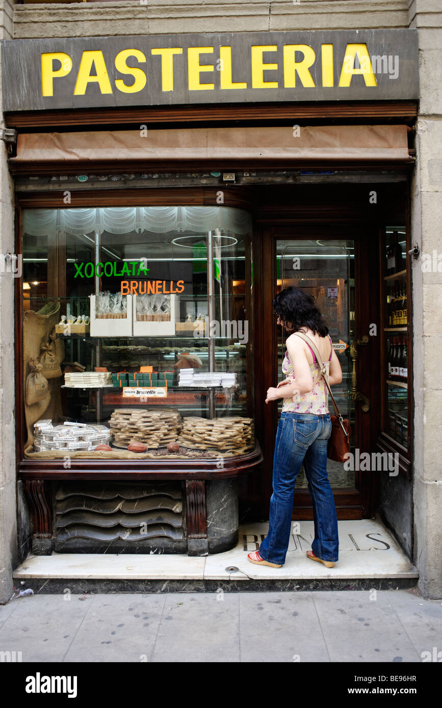 Girl window shopping in old traditional bakery . Barri Gotic. Barcelona