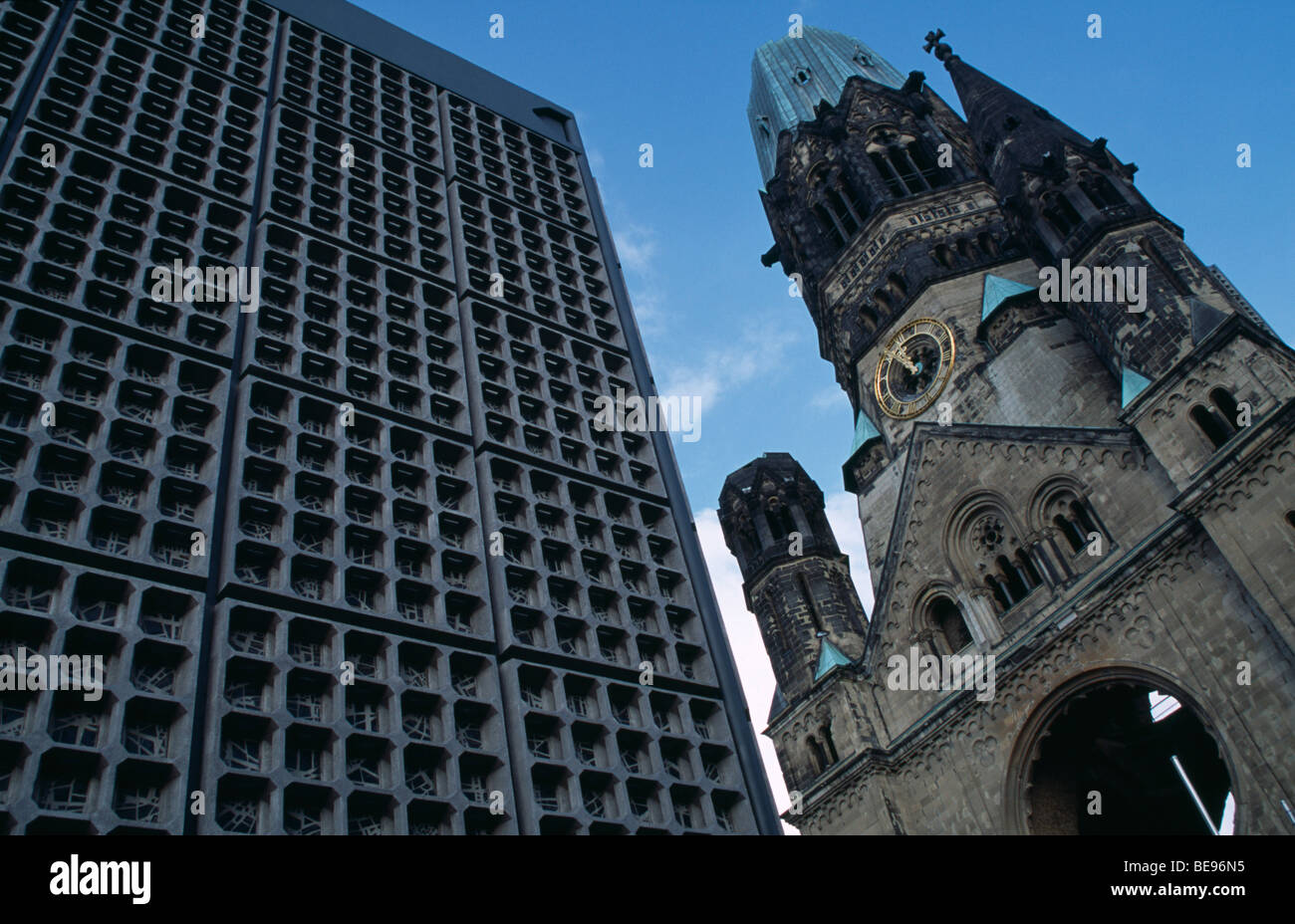 GERMANY Berlin Kaiser Wilhelm Memorial Church. Part view of ruined Gothic exterior with clock face beside new building. Stock Photo