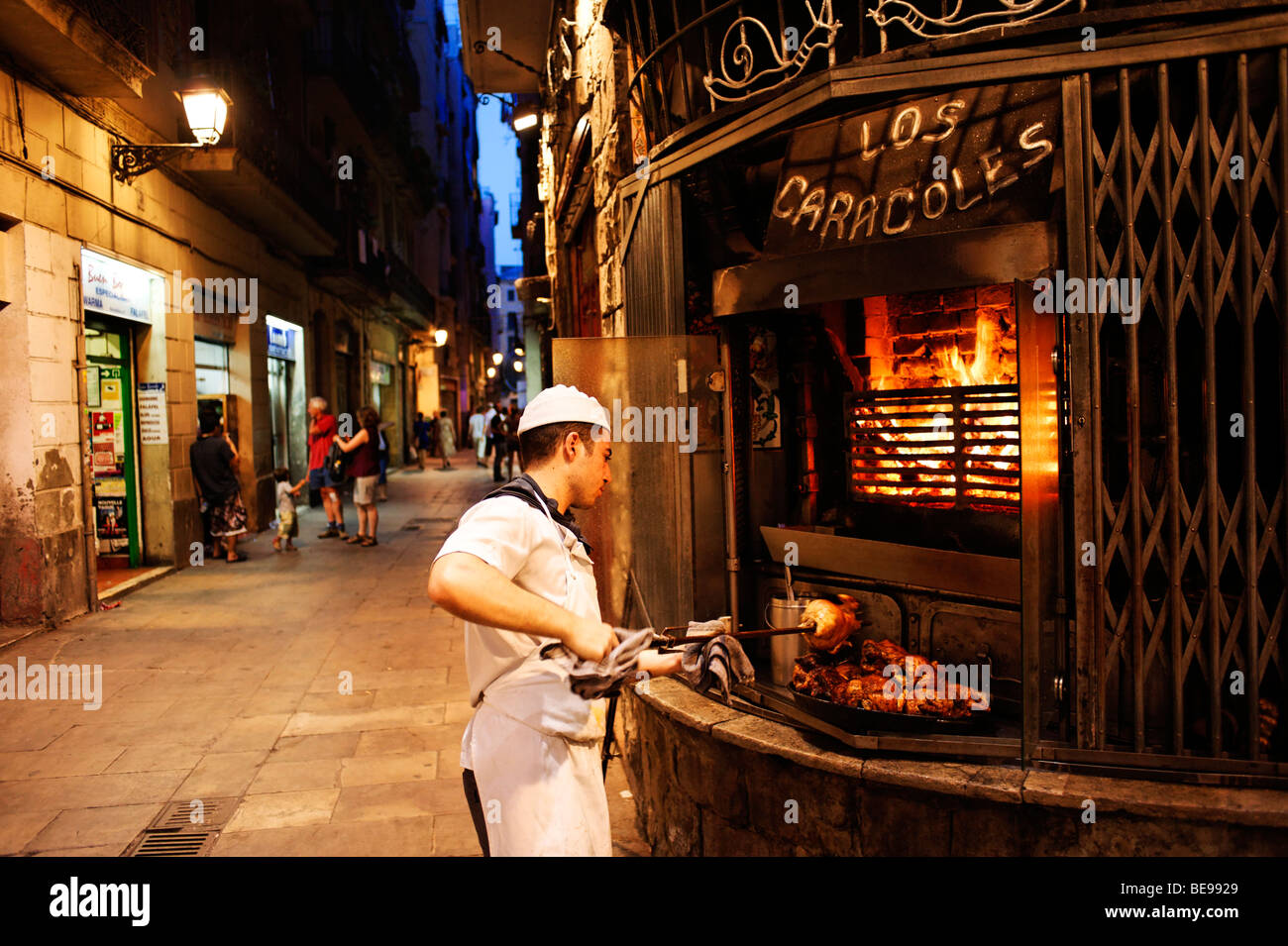 Chef roasting chickens on a spit outside Los Caracoles restaurant. Barri Gottic. Barcelona. Spain Stock Photo