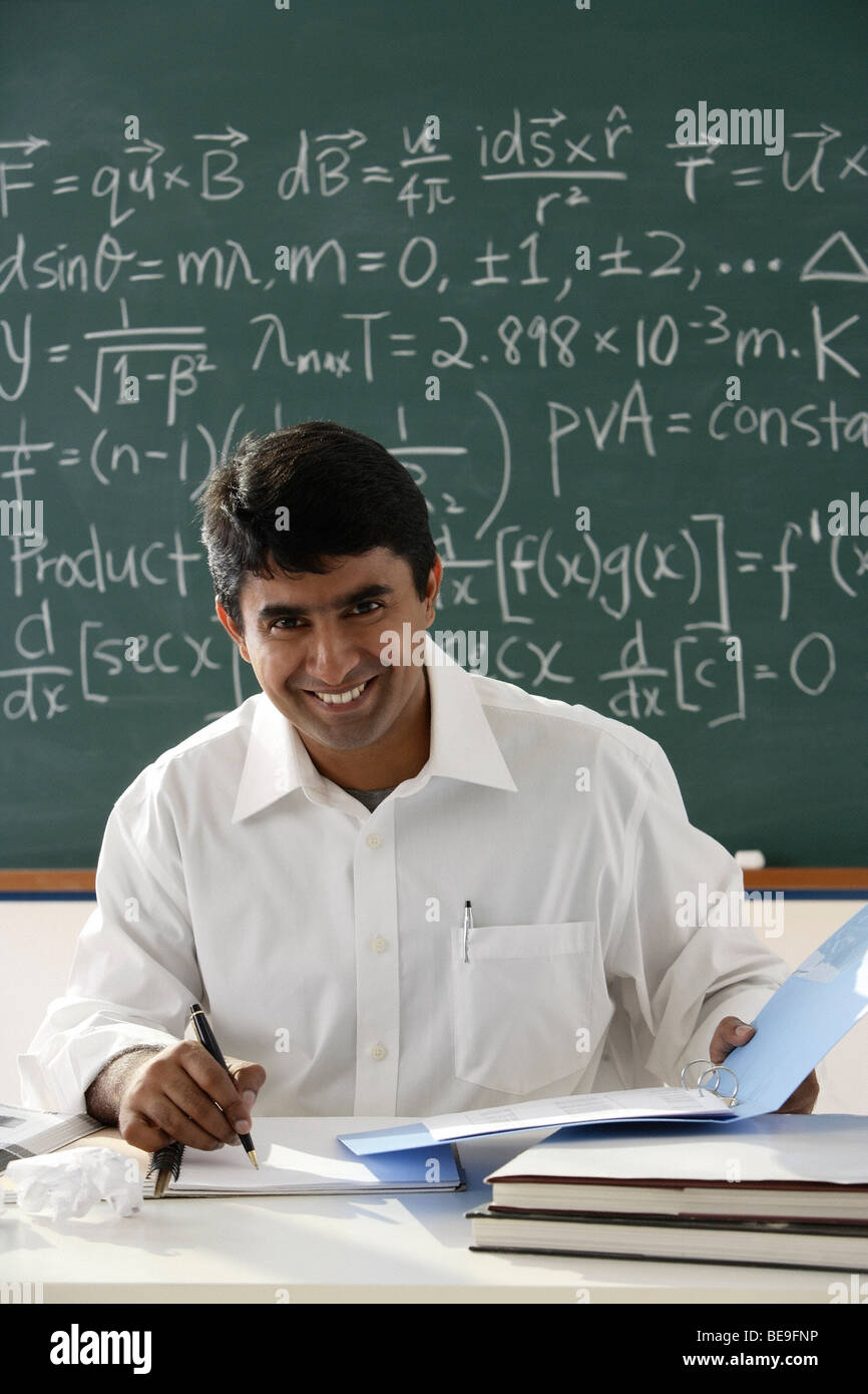 teacher sitting at desk Stock Photo - Alamy