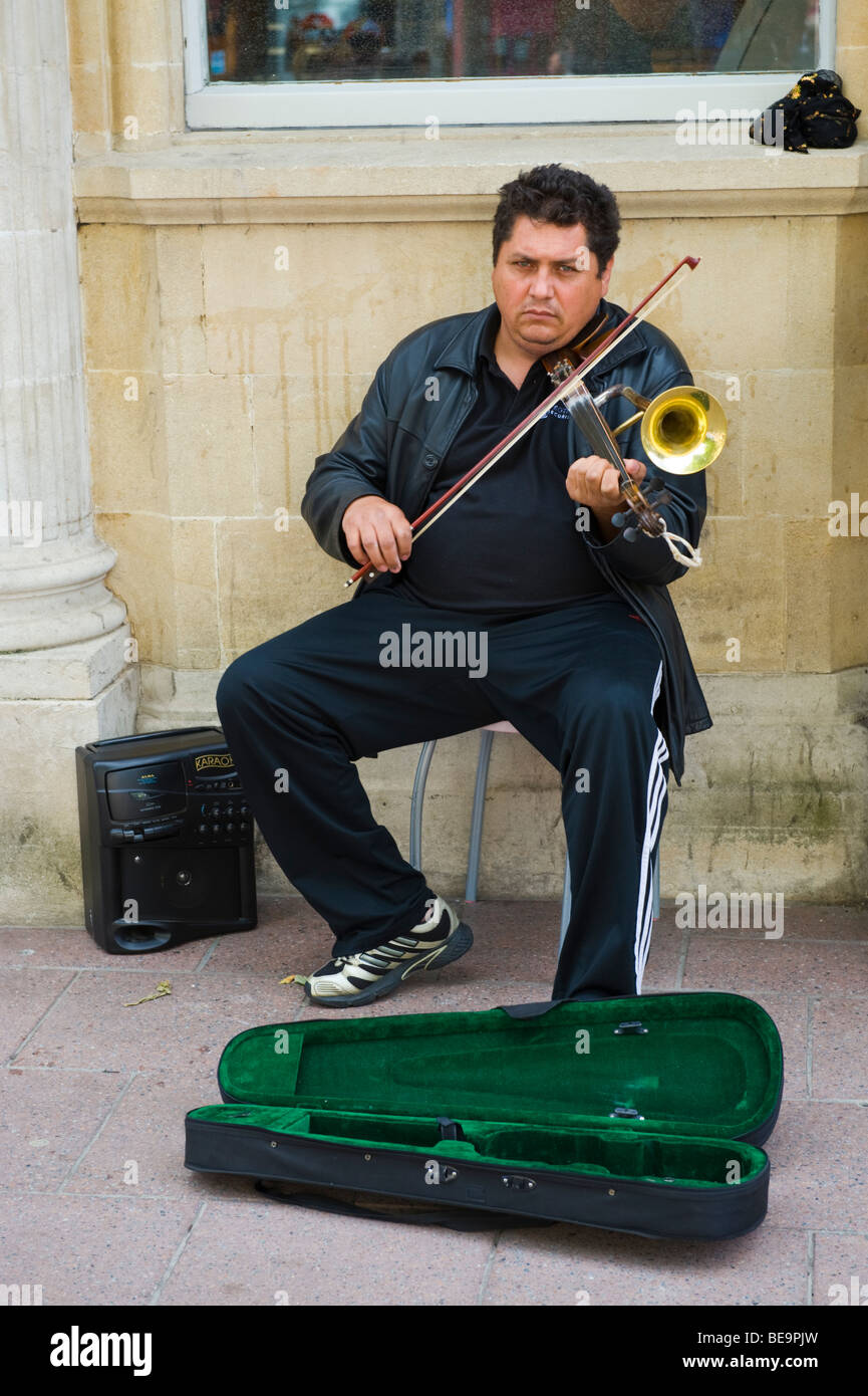 Busker playing Romanian horn violin on shopping street in city centre of Cardiff South Wales UK Stock Photo