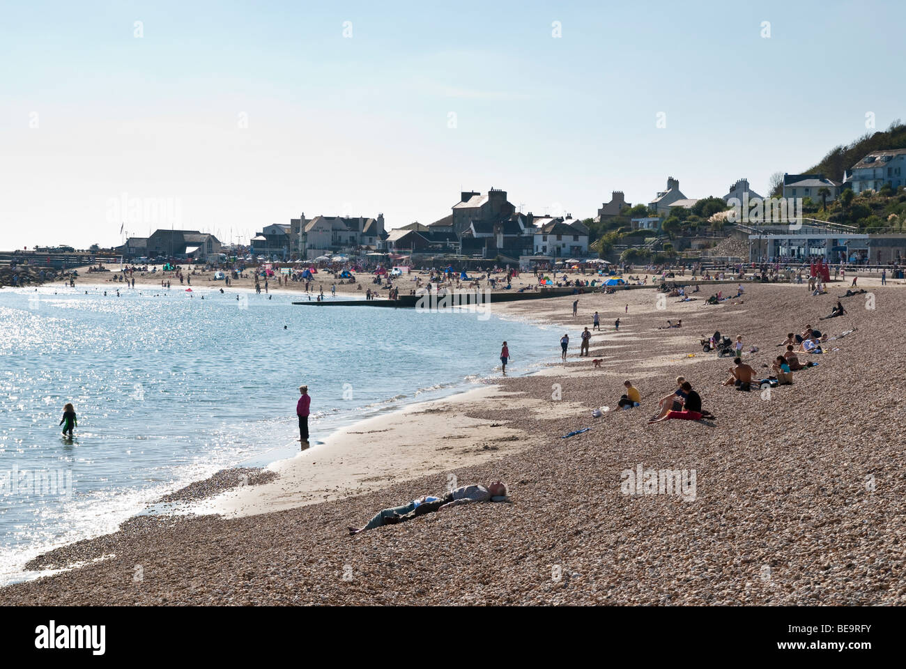 Holiday makers on the pebble beach at Lyme Regis, Dorset Stock Photo