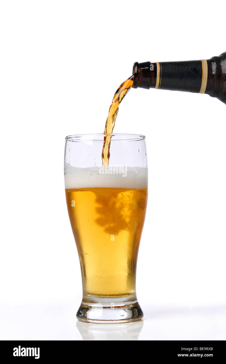 Beer being pour on a glass isolated against a white background Stock Photo