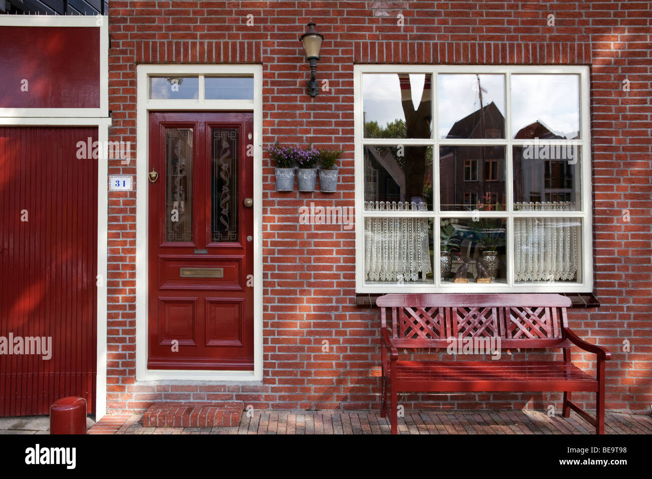 Red brick house front with red bench and red front-door .Edam, the Netherlands Stock Photo