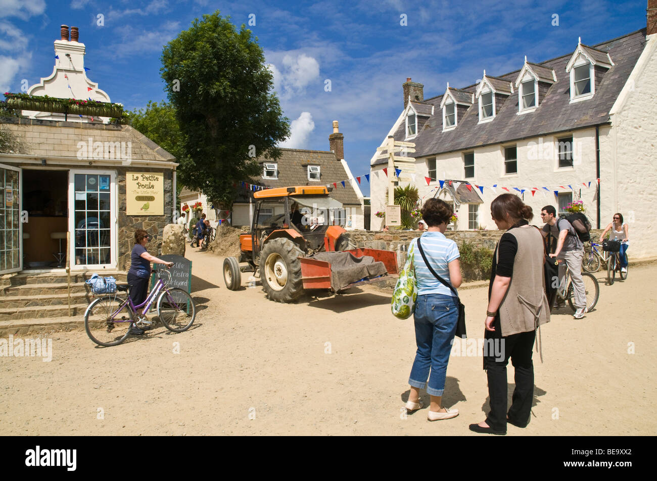 dh  SARK VILLAGE SARK ISLAND Tourists bicycles tractor traffic at village crossroads Stock Photo