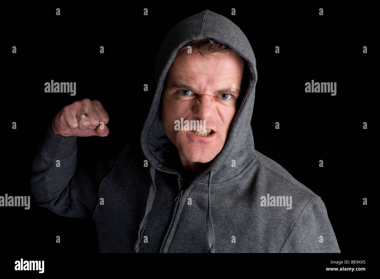 A hooded man clinching his fist Stock Photo