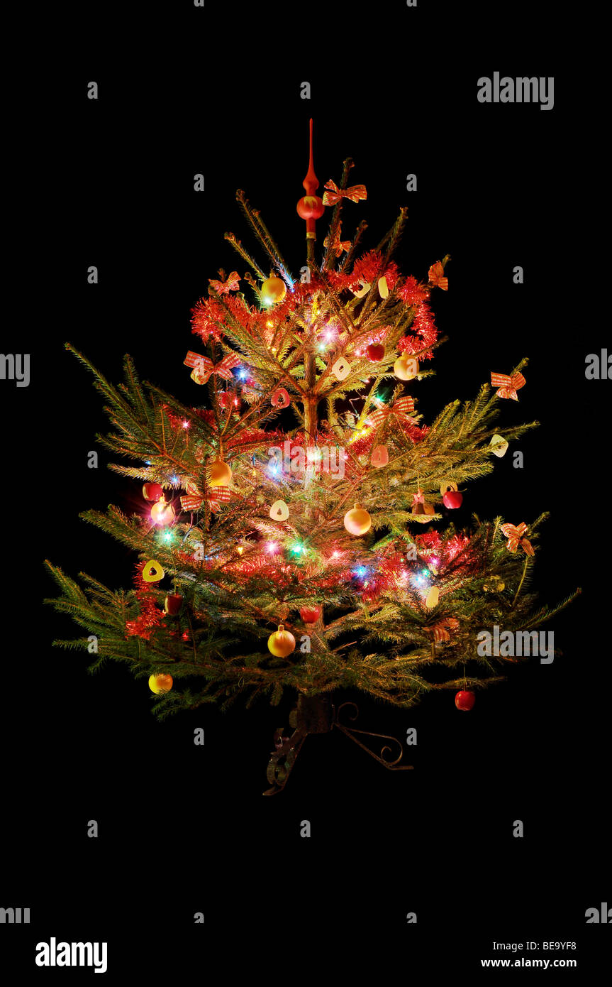 Traditional decorated Christmas tree isolated on black background. Stock Photo
