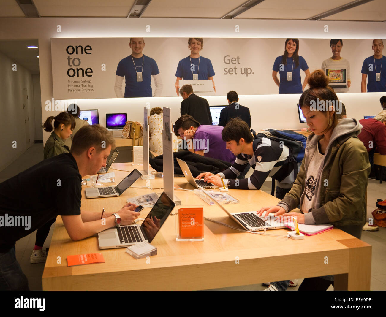 customers trying out computers at Apple Store, Regent Street, London