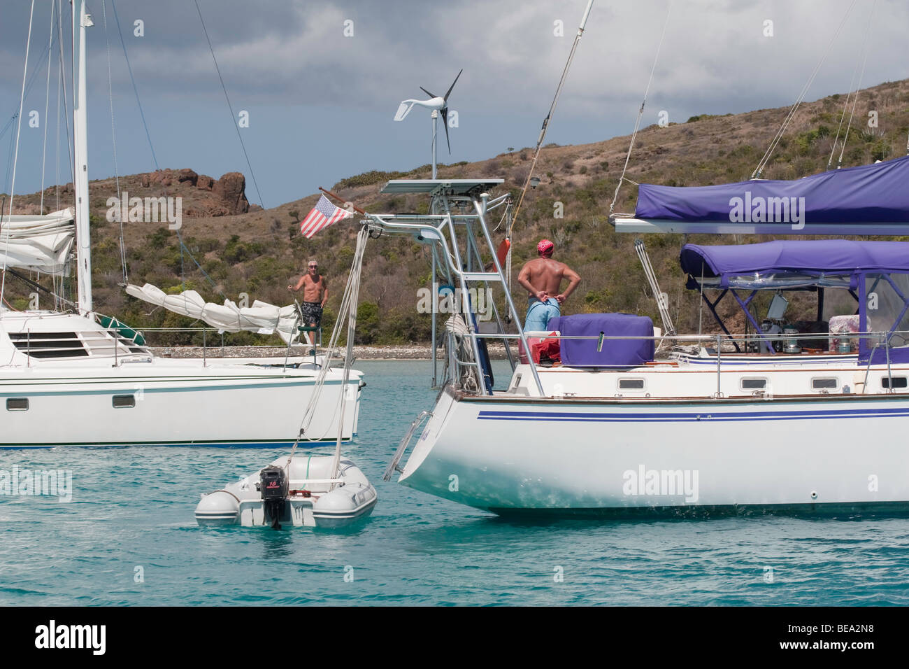 Men chatting between Sailboats anchored in Bahia de Tortuga Culebrita, PR Stock Photo