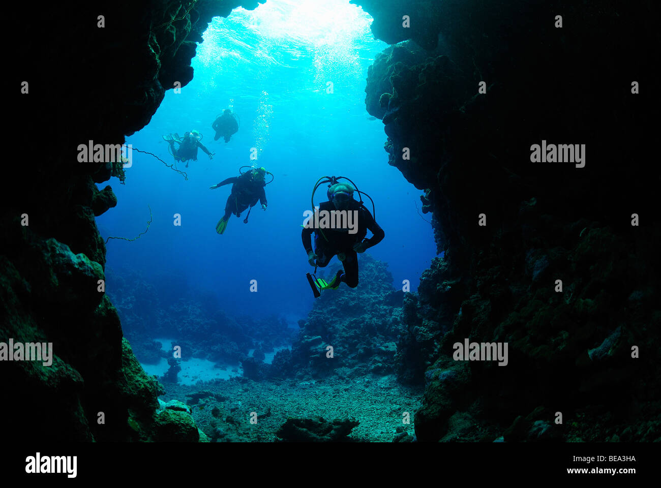 Scuba divers going inside an underwater cave, Red Sea Stock Photo