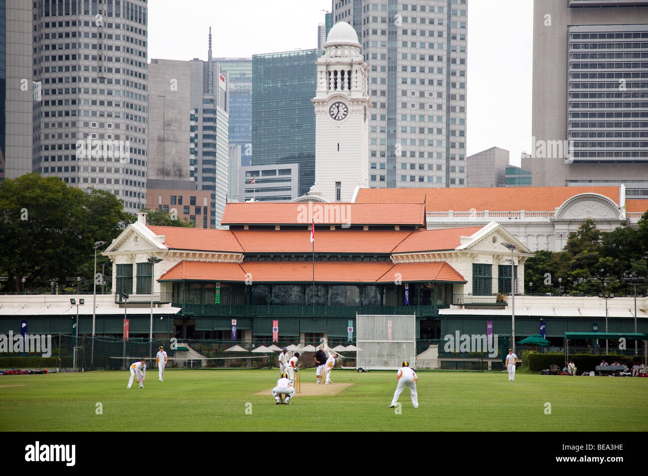 School children play cricket on the padang at Singapore Cricket Club Stock Photo