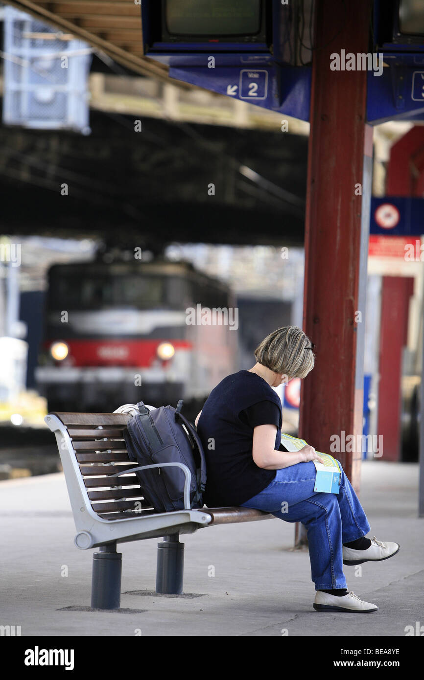 Woman, alone, on the platform of a station Stock Photo