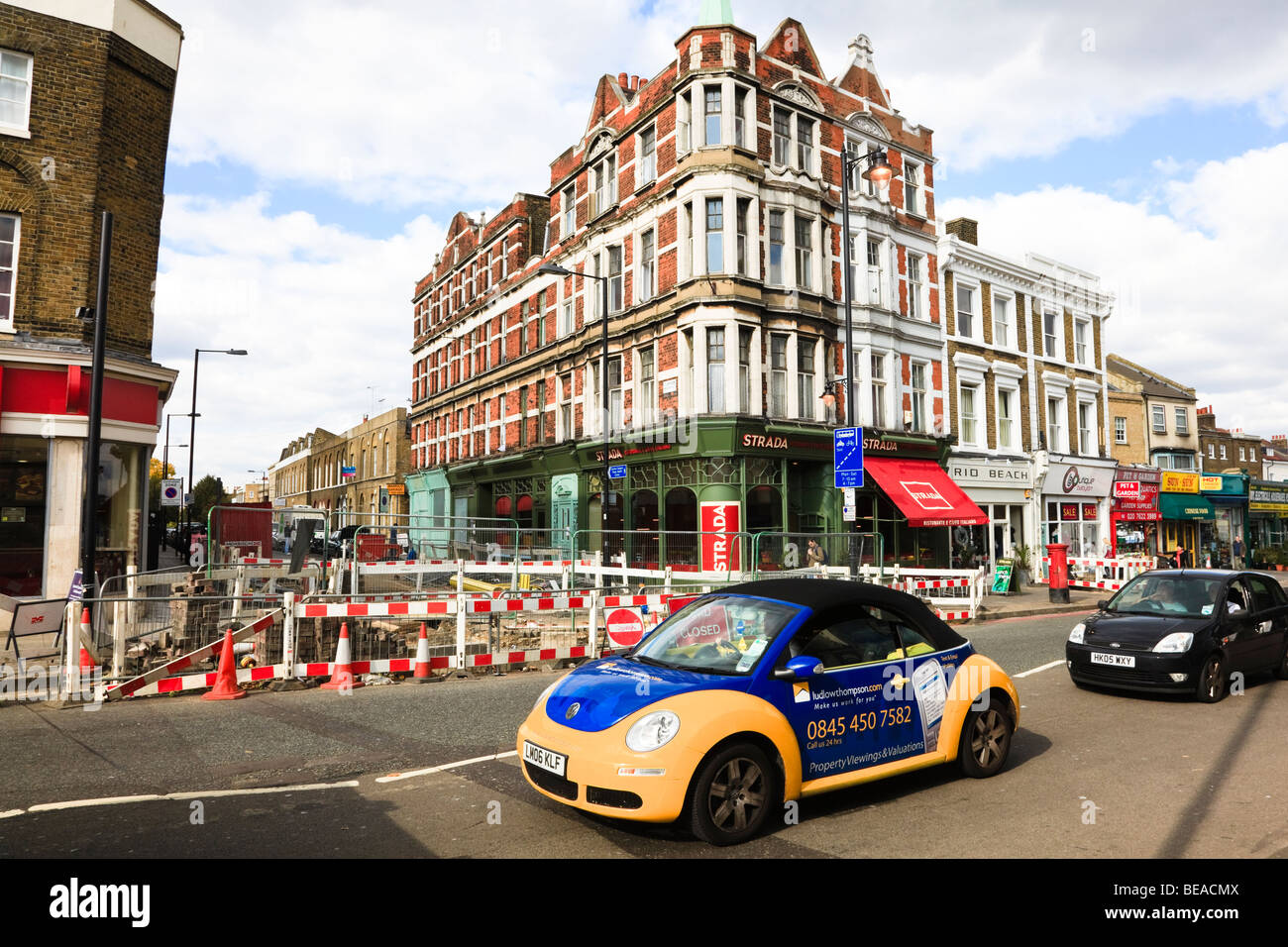 Yellow and Blue Volkswagen car in Clapham High Street, advertising an Estate agency, London, Uk Stock Photo