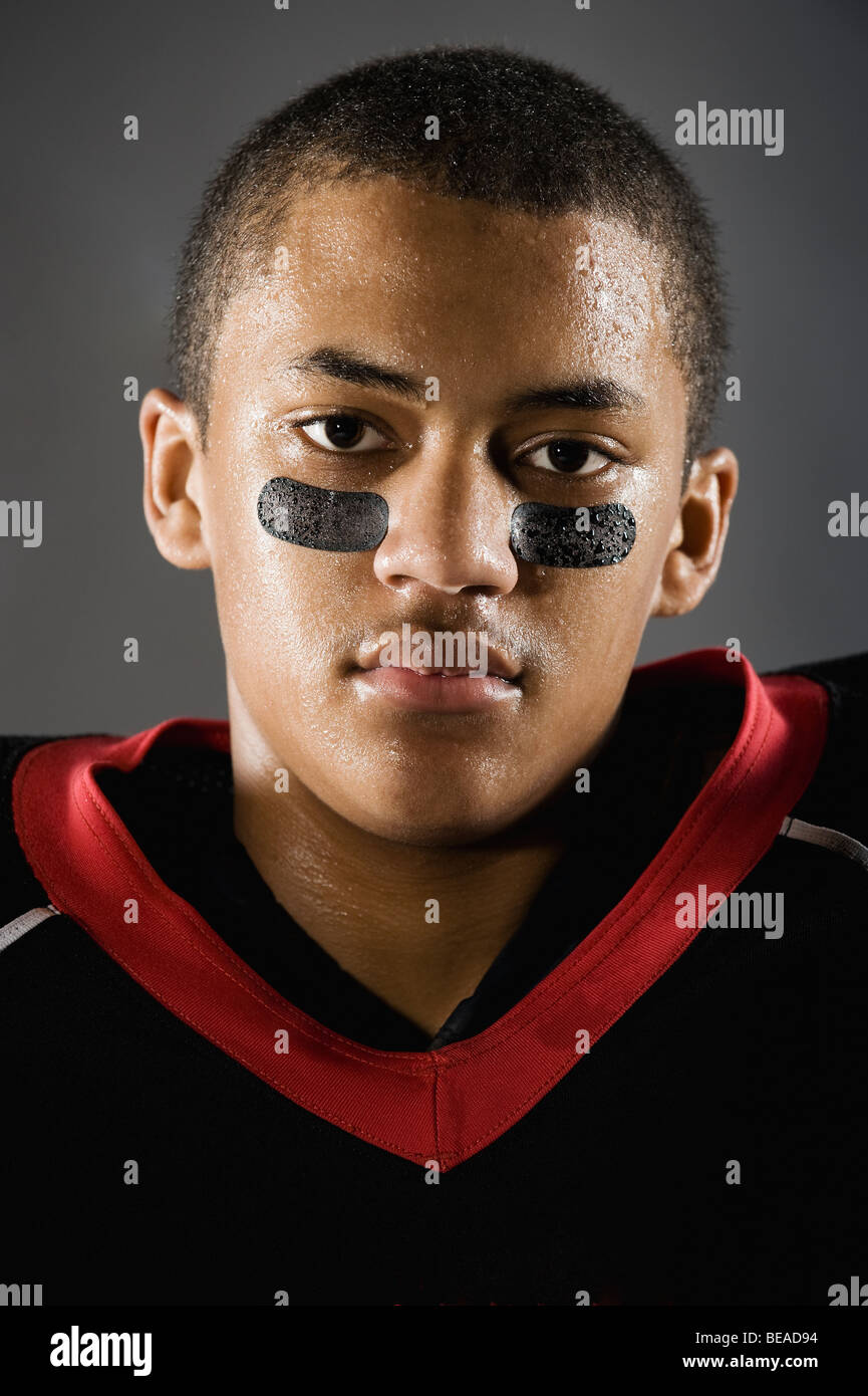 Mixed race football player with face paint under eyes Stock Photo