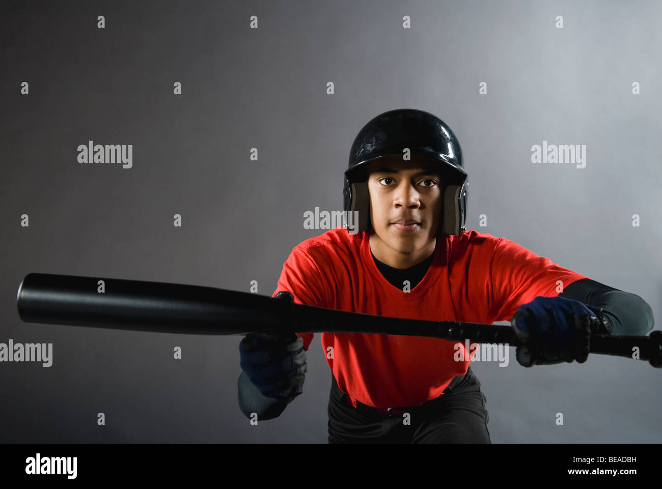 Mixed race baseball player ready to bunt with baseball bat Stock Photo