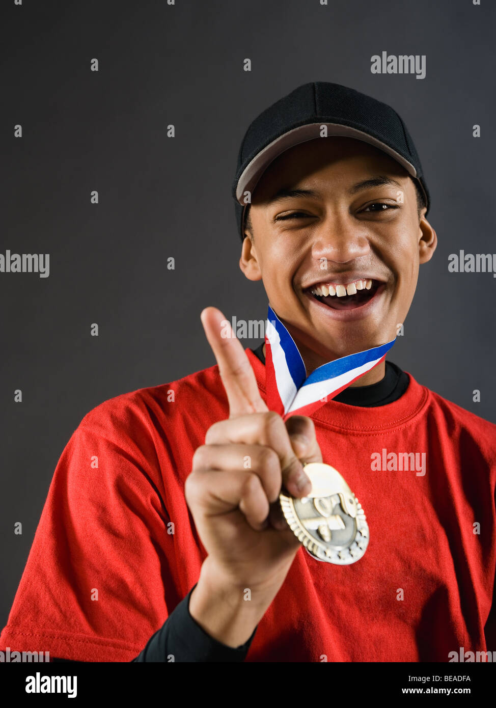 Mixed race baseball player gesturing with award medal Stock Photo