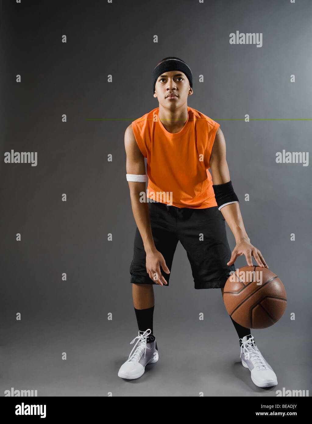 Mixed race basketball player dribbling basketball Stock Photo Alamy