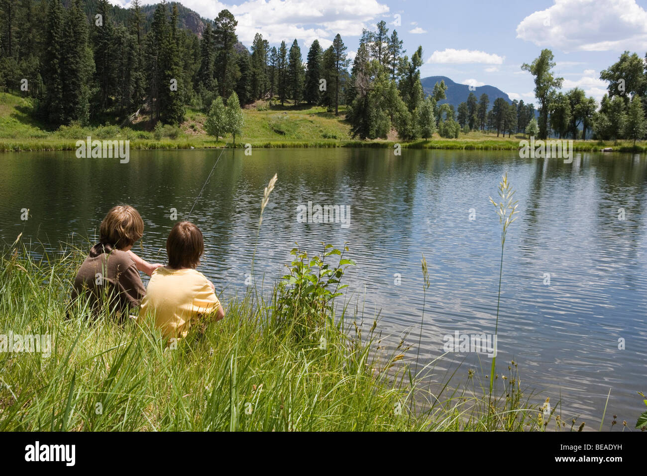 Two boys fishing at the edge of a lake, Durango, Colorado, USA Stock Photo