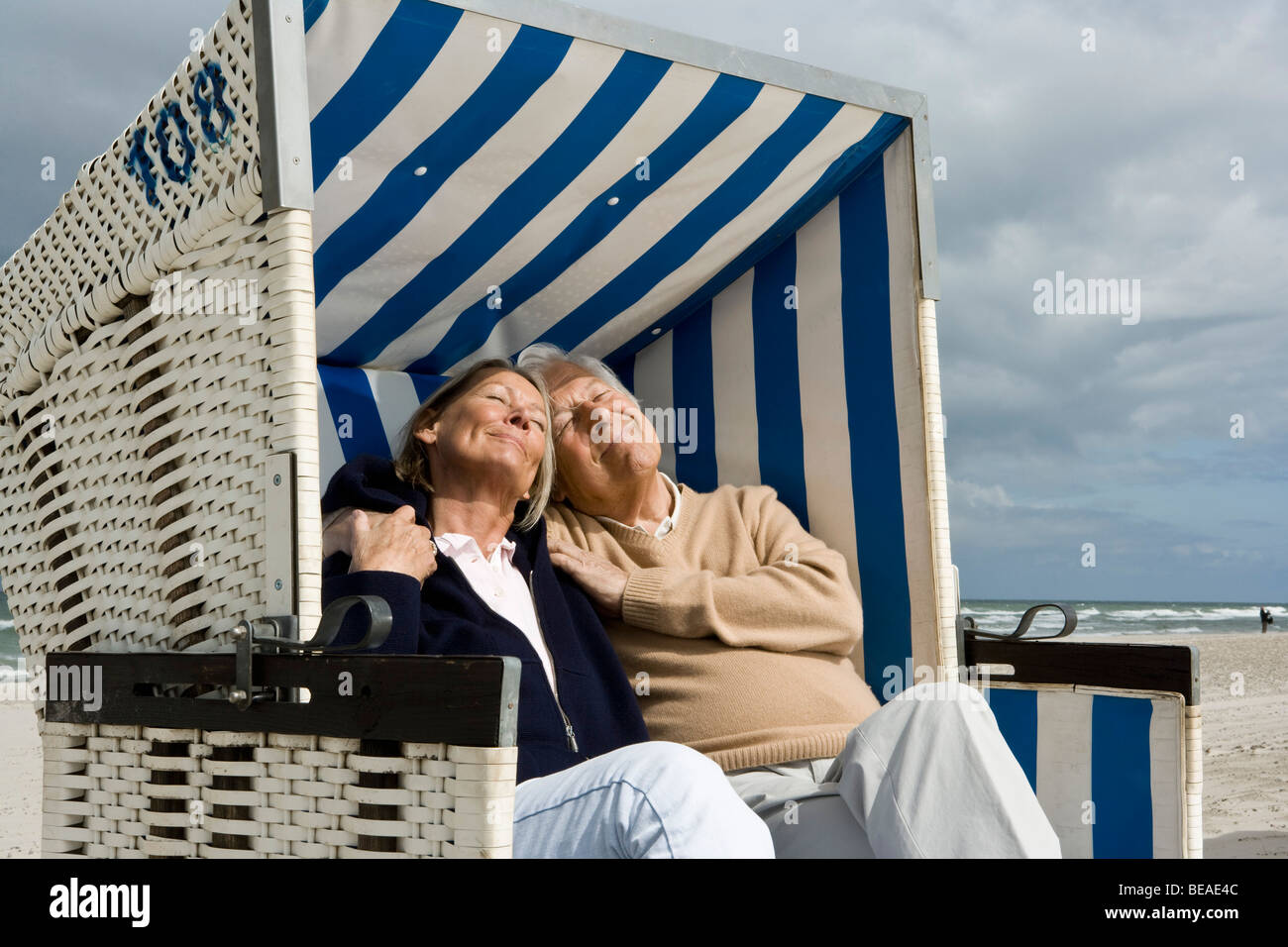 A senior couple sitting together in a hooded beach chair Stock Photo ...