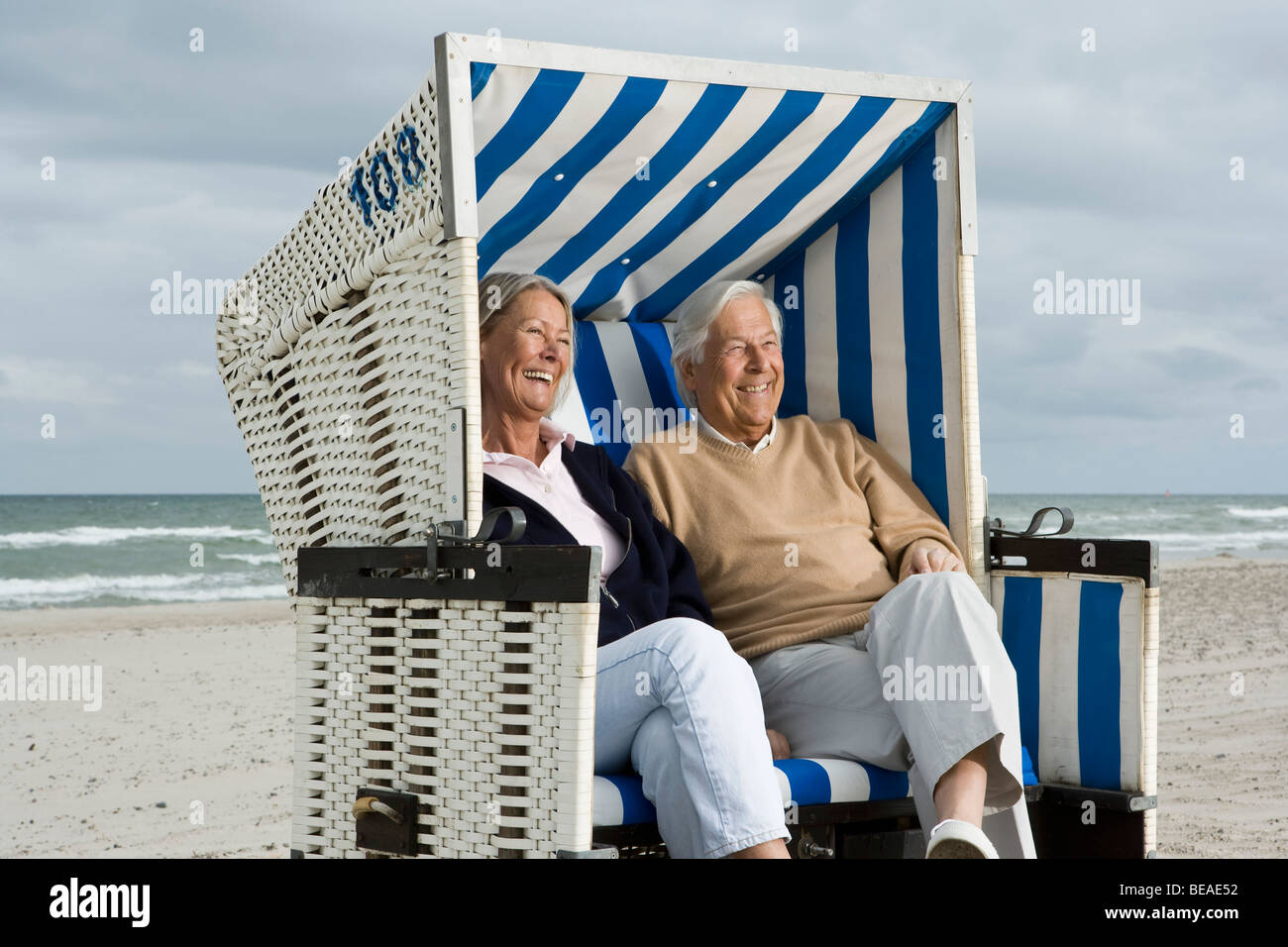 A senior couple sitting together in a hooded beach chair Stock Photo ...