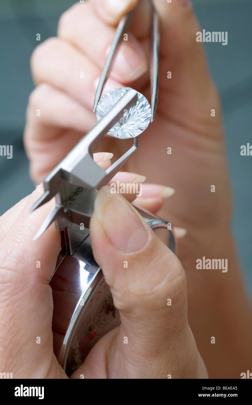 A jeweler using a diamond gauge on a diamond Stock Photo