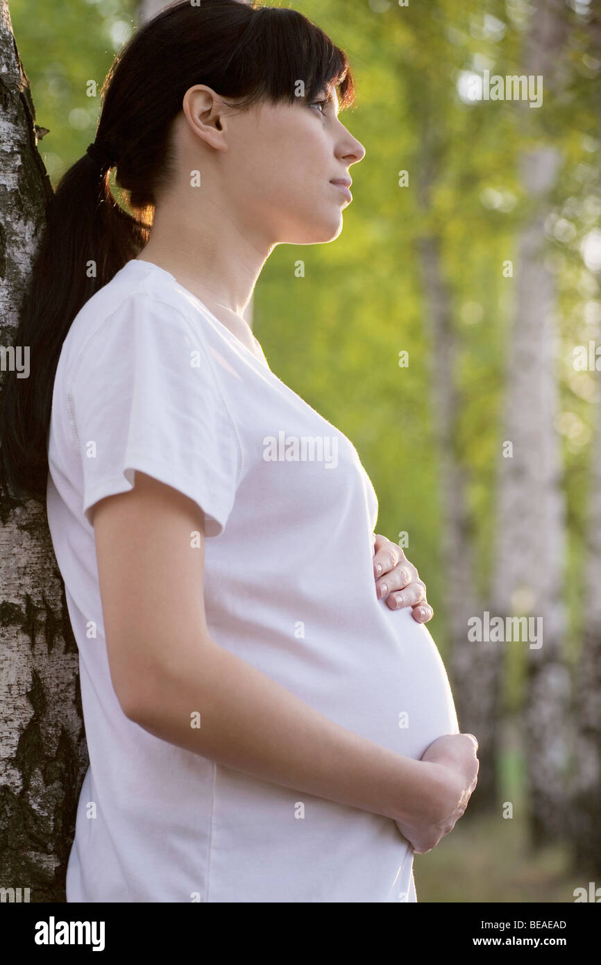 A pregnant woman holding her stomach, outdoors Stock Photo - Alamy
