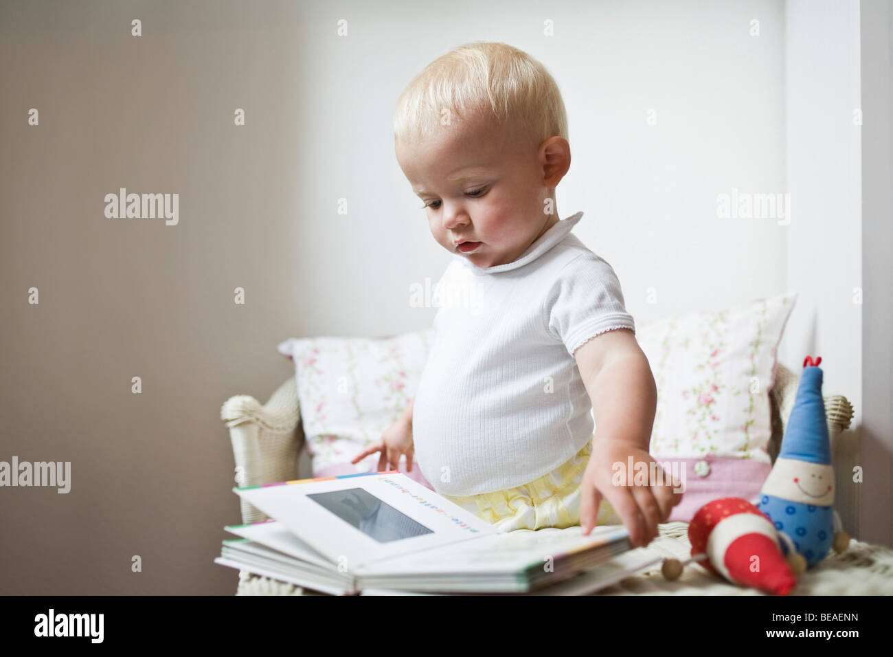 A toddler looking at a picture book Stock Photo