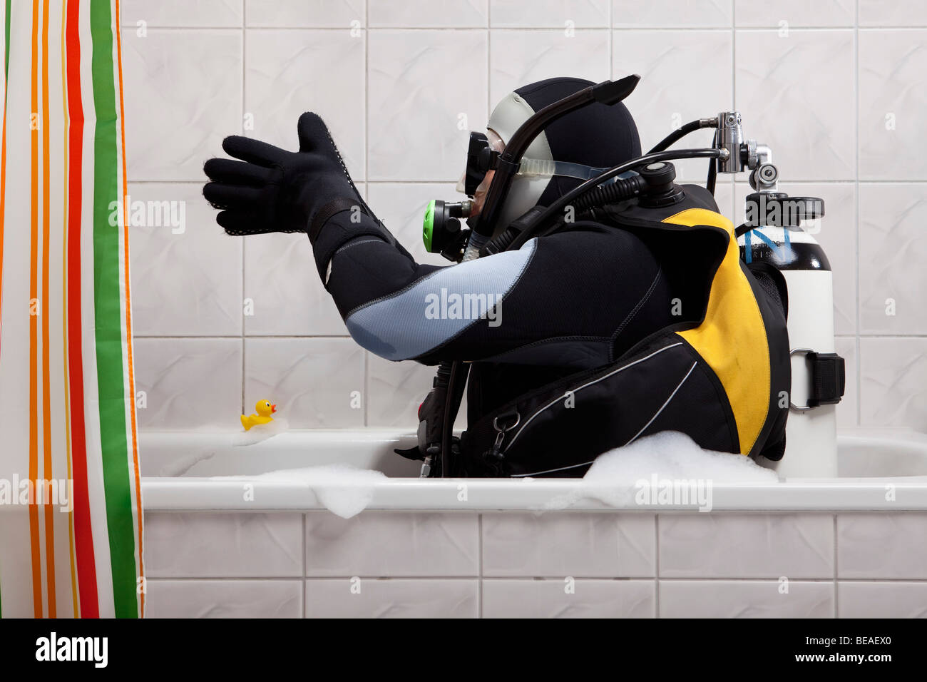 A scuba diver sitting in a bathtub preparing to dive in Stock Photo Alamy