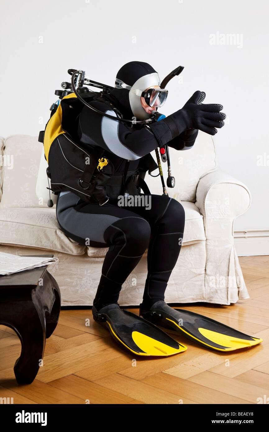 A scuba diver diving off a couch in a living room Stock Photo Alamy
