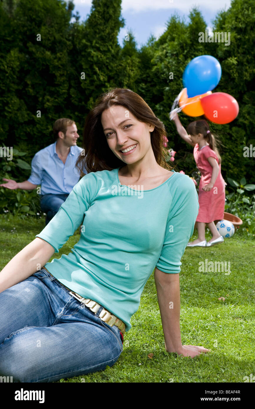 Portrait of a woman sitting on a lawn Stock Photo - Alamy