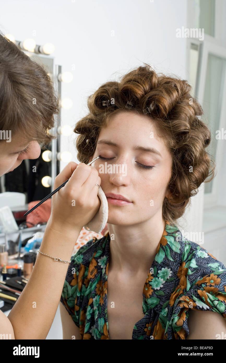 A make-up artist applying make-up on a model Stock Photo