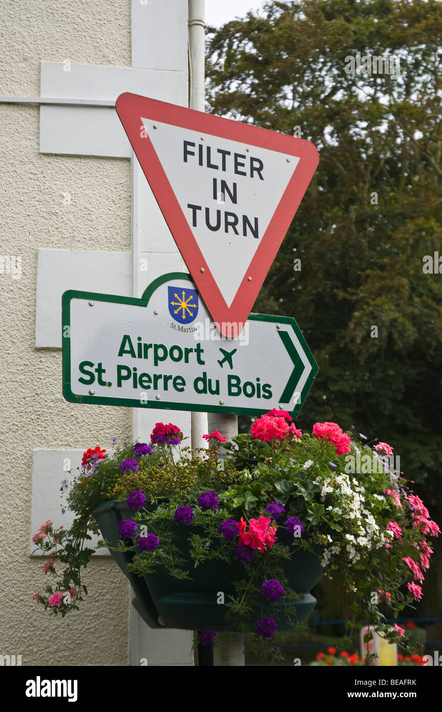 dh  ST MARTIN GUERNSEY Guernsey traffic junction filter in turn sign with flowers signpost road channel islands Stock Photo