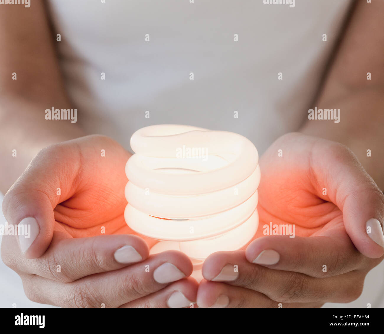 Woman holding glowing compact fluorescent bulb Stock Photo Alamy