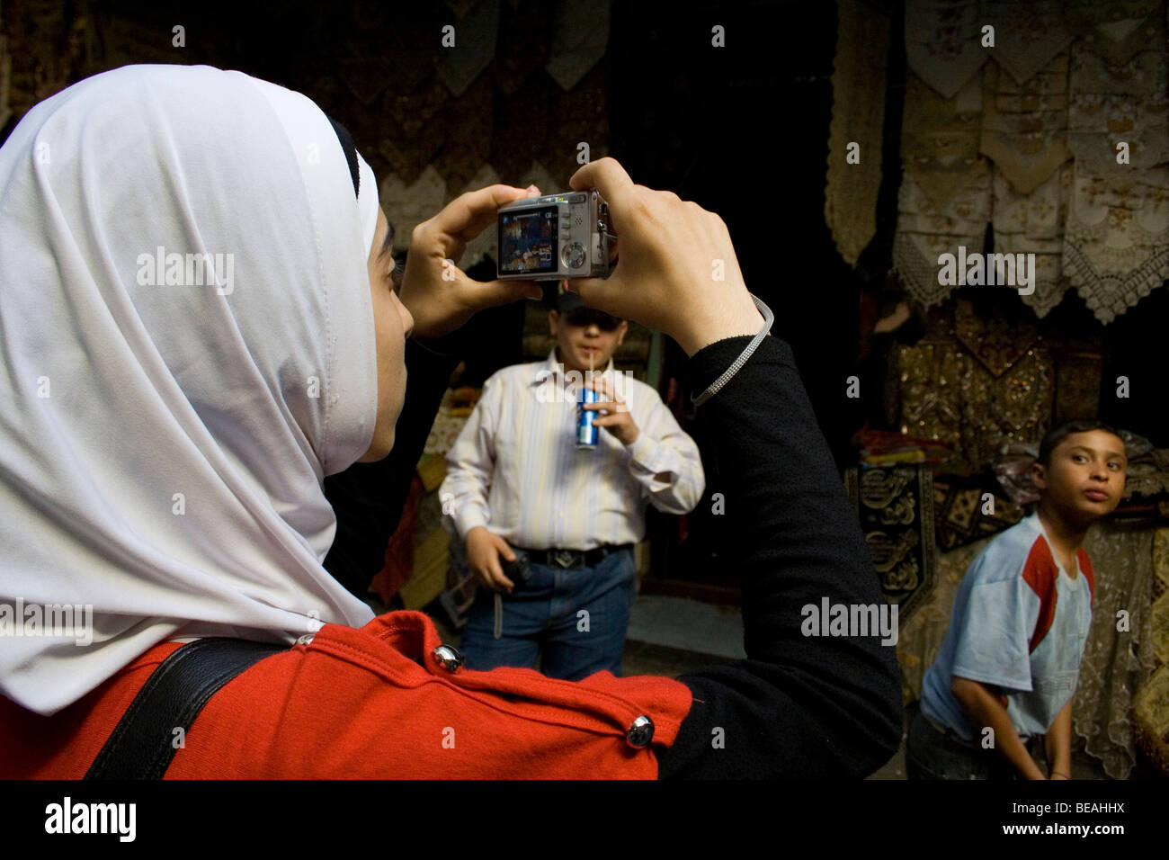 young Syrian girl in Damascus Market taking a picture during a photography training course run by refocus Stock Photo