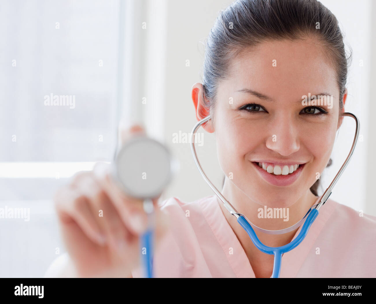 Mixed race nurse holding stethoscope Stock Photo
