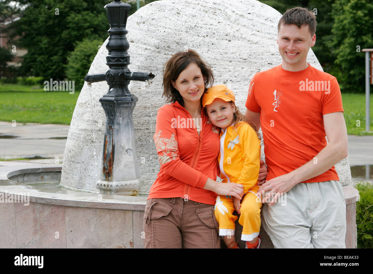 Family with one child standing at fountain. Stock Photo