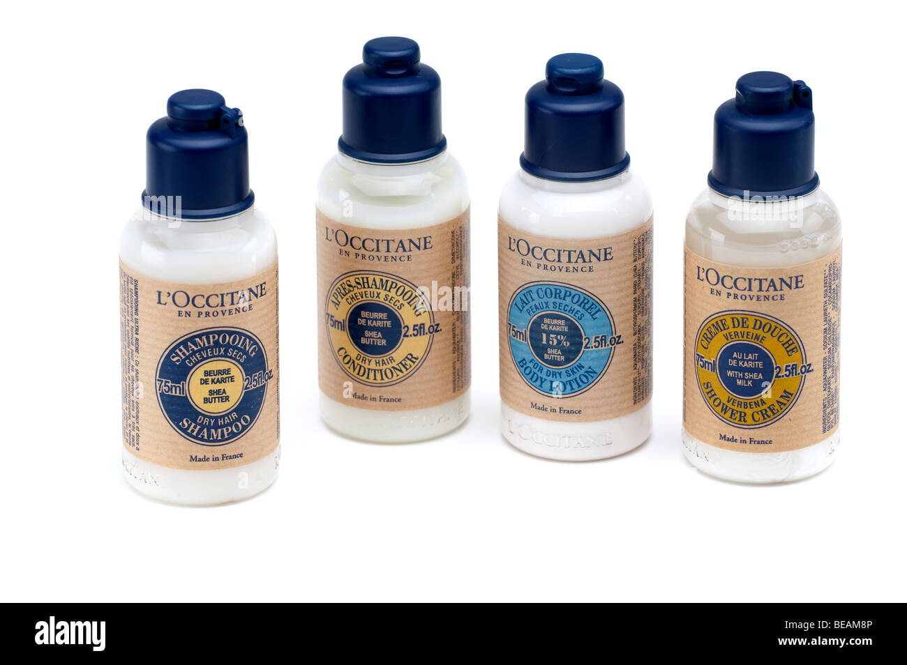 Four plastic bottles of one of each L'Occitane Shampoo,conditioner,body lotion and shower cream Stock Photo