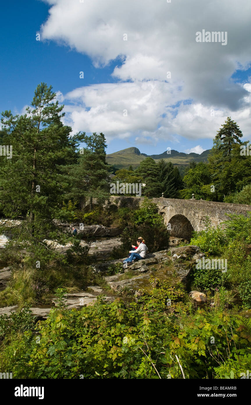 dh Falls of Dochart KILLIN STIRLINGSHIRE Tourist couple overlooking River Dochart and bridge tourists scotland landscape holiday countryside Stock Photo
