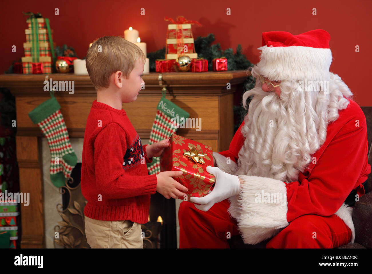 Santa Claus gives young boy Christmas gift Stock Photo